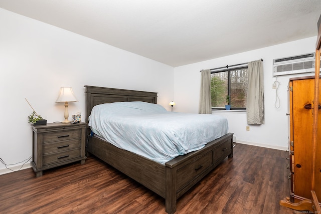 bedroom featuring dark wood-type flooring and an AC wall unit