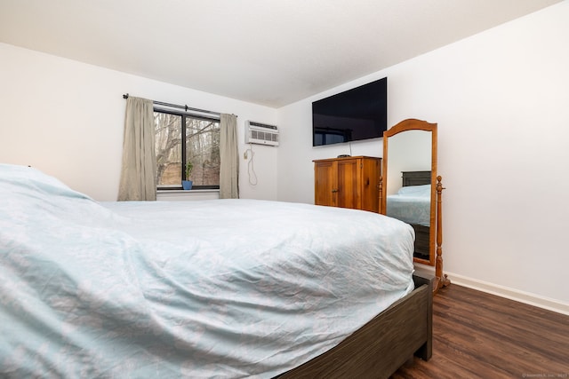 bedroom with dark hardwood / wood-style flooring and a wall mounted air conditioner