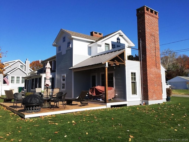 rear view of house featuring a yard, a patio area, and an outdoor fire pit