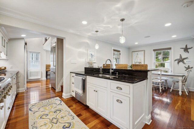 kitchen featuring pendant lighting, sink, dark wood-type flooring, white cabinetry, and dark stone counters