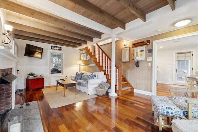 living room featuring beamed ceiling, hardwood / wood-style flooring, and wooden ceiling