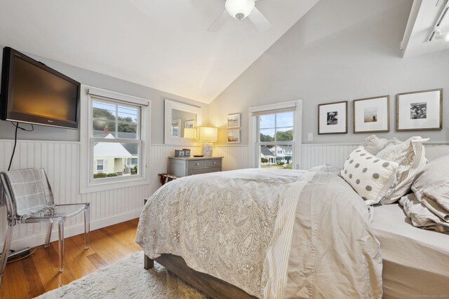 bedroom with multiple windows, vaulted ceiling, hardwood / wood-style flooring, and ceiling fan