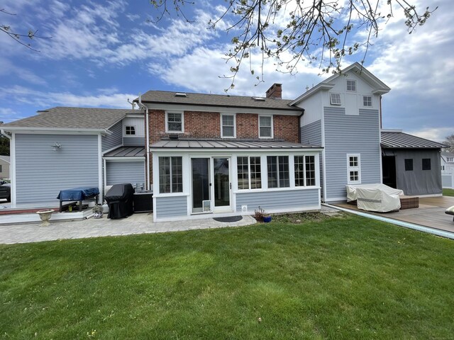 rear view of property with a lawn and a patio area