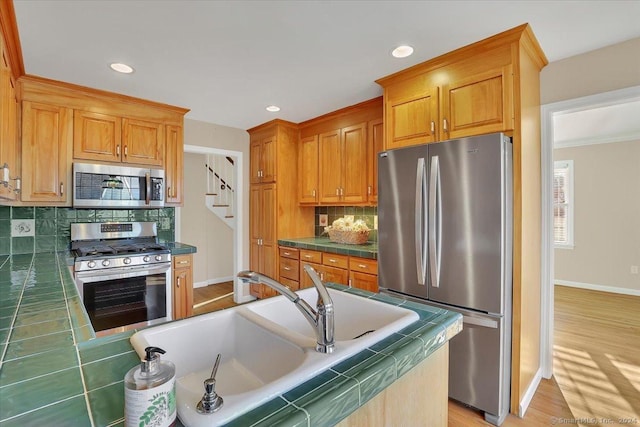 kitchen featuring tasteful backsplash, tile countertops, sink, and stainless steel appliances