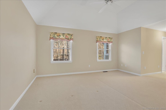 carpeted empty room featuring vaulted ceiling, a wealth of natural light, and ceiling fan