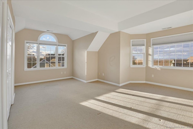 additional living space with light colored carpet and vaulted ceiling