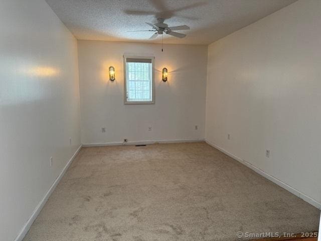 carpeted empty room featuring ceiling fan and a textured ceiling