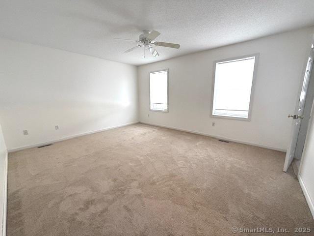 spare room with ceiling fan, carpet, and a textured ceiling