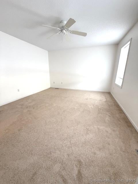 carpeted empty room with a textured ceiling and ceiling fan