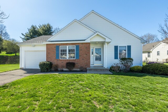 view of front facade with aphalt driveway, brick siding, a front yard, and a garage