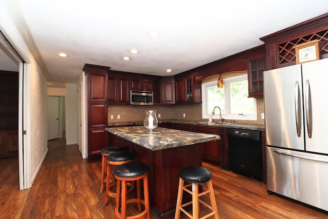 kitchen with glass insert cabinets, dark wood-style floors, appliances with stainless steel finishes, and a sink