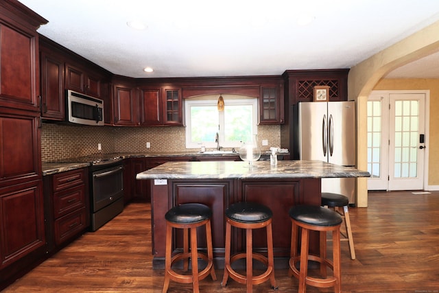 kitchen featuring a sink, stainless steel appliances, dark wood-type flooring, and dark brown cabinets