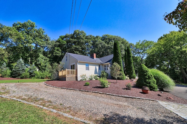 view of side of property featuring a chimney and driveway