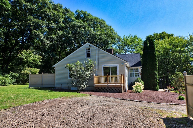 view of front facade featuring a deck, a front yard, and fence