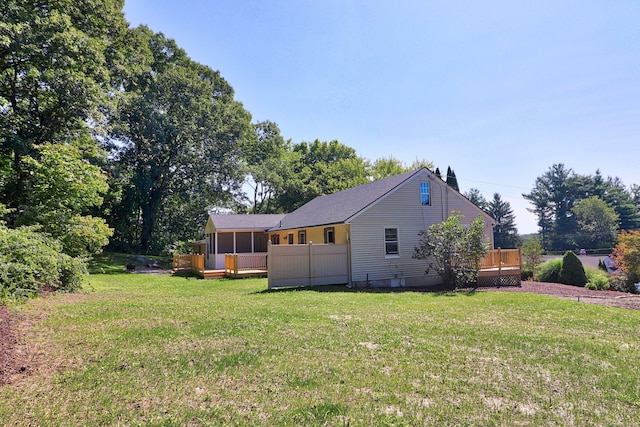 view of home's exterior featuring a yard, a deck, and a sunroom