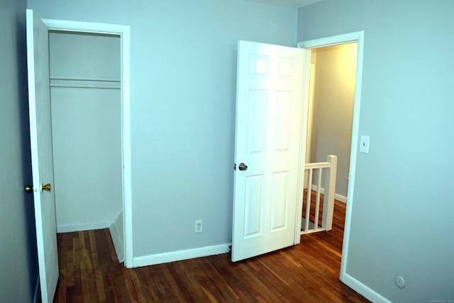 unfurnished bedroom featuring dark hardwood / wood-style flooring and a closet