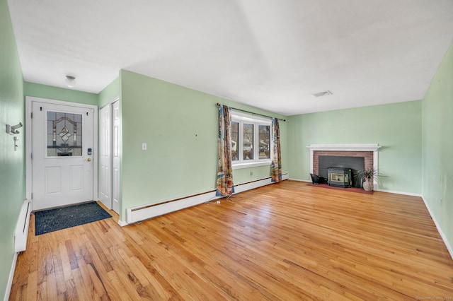 unfurnished living room featuring a baseboard radiator and light hardwood / wood-style flooring