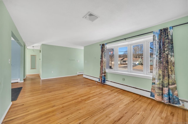 unfurnished room featuring a baseboard radiator and light hardwood / wood-style flooring