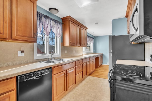 kitchen featuring backsplash, sink, and black appliances