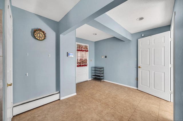 empty room featuring light tile patterned floors and baseboard heating