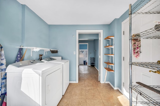 washroom featuring washing machine and dryer and light tile patterned floors