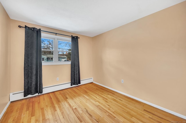 spare room featuring hardwood / wood-style flooring and a baseboard radiator