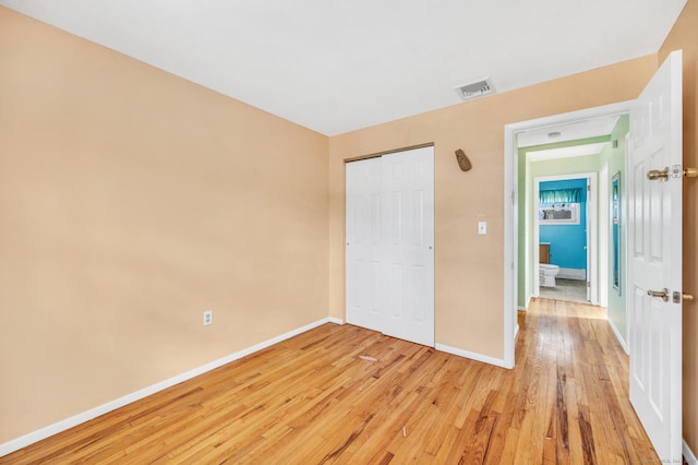 unfurnished bedroom with a closet and light hardwood / wood-style flooring