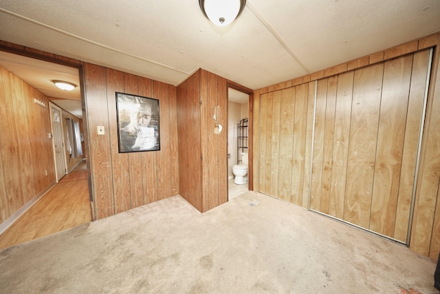 empty room with light carpet and wooden walls