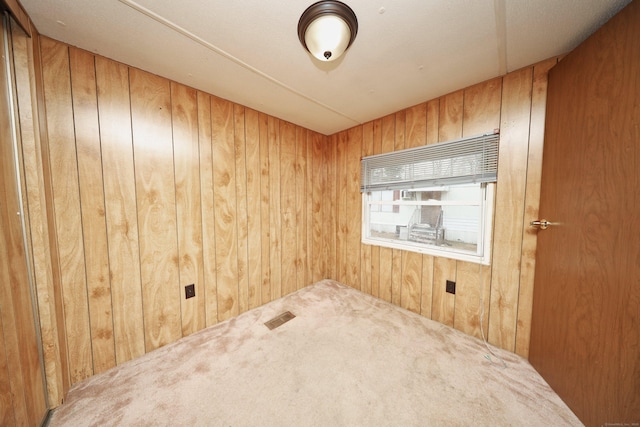 empty room with carpet and wooden walls