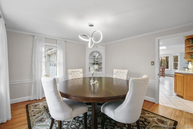 dining space featuring crown molding and light wood-type flooring