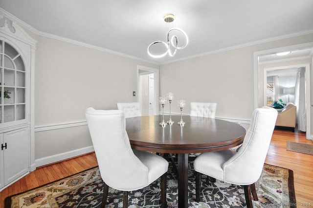 dining space with hardwood / wood-style flooring and ornamental molding