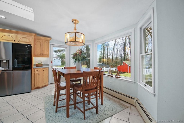 dining room with a baseboard radiator, light tile patterned floors, a wealth of natural light, and an inviting chandelier