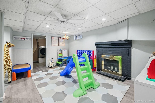 recreation room with ceiling fan, hardwood / wood-style floors, and washer / dryer