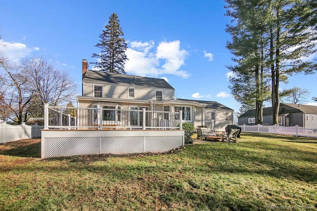 rear view of property with a yard and a wooden deck