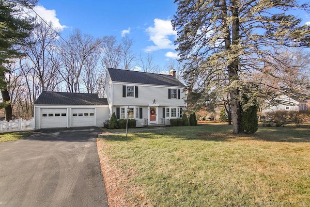 colonial home featuring a garage and a front lawn