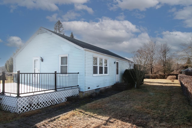 view of side of property with a wooden deck and a yard