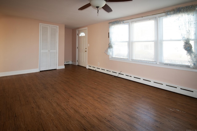 unfurnished room featuring baseboard heating, ceiling fan, and dark wood-type flooring