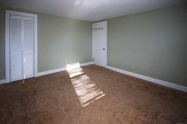 unfurnished bedroom featuring carpet flooring and a closet