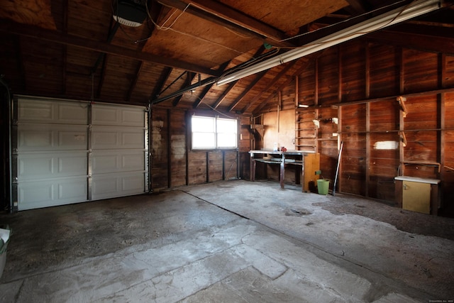 garage with a garage door opener and wooden walls