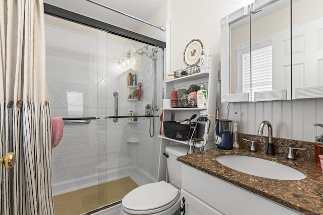 bathroom with an enclosed shower, vanity, and toilet