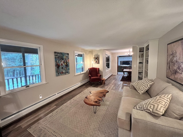 living room featuring baseboard heating, built in shelves, hardwood / wood-style floors, and an inviting chandelier