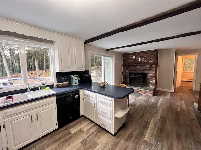 kitchen featuring sink, a brick fireplace, black dishwasher, beamed ceiling, and white cabinetry