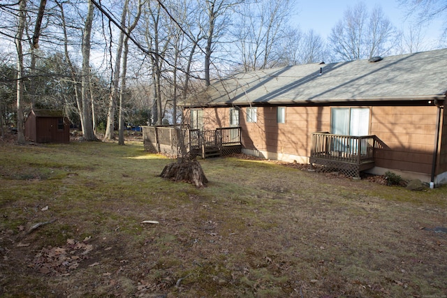 view of yard featuring a wooden deck and a storage unit