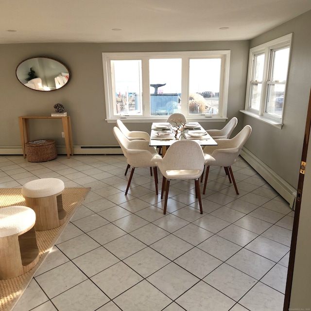 tiled dining room with a baseboard heating unit