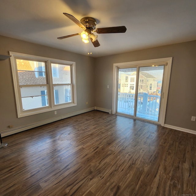 empty room featuring dark hardwood / wood-style flooring, ceiling fan, and baseboard heating