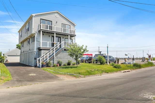 view of front of property featuring an outbuilding, a garage, a front yard, and a porch