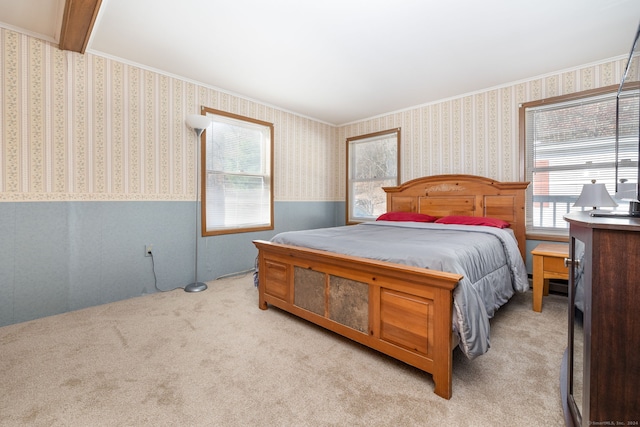 bedroom featuring crown molding and light colored carpet