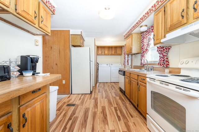 kitchen with sink, washing machine and clothes dryer, white appliances, and light hardwood / wood-style flooring