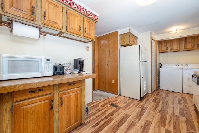 kitchen featuring crown molding, washer and clothes dryer, white appliances, and light hardwood / wood-style floors