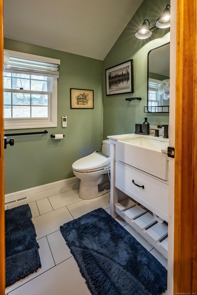 bathroom with vaulted ceiling, vanity, tile patterned floors, and toilet